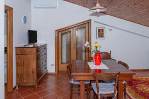 a dining room with a wooden table and a television at Assisi Green Country Apt with parking & Netflix in Assisi