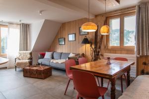 a living room with a table and a couch at Terre de Sapins in Orbey
