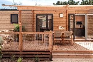 a wooden cabin with a table and chairs on a deck at L'Orée de l'Océan - Vendée in Landevieille