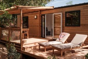 Cette cabine dispose d'une terrasse avec deux chaises et une table. dans l'établissement L'Orée de l'Océan - Vendée, à Landevieille