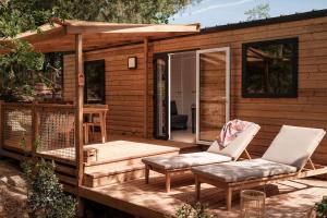 a cabin with a deck with two chairs and a table at L'Orée de l'Océan - Vendée in Landevieille