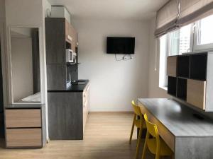 a kitchen with a table and yellow chairs in a room at StarterApart Wrocław in Wrocław