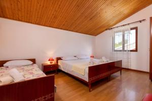a bedroom with two beds and a wooden ceiling at House Domenico in Rovinj