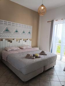 1 dormitorio con 1 cama grande y toallas. en Meltemi apartments, en Agia Marina Aegina