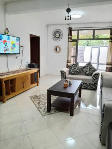 a living room with a couch and a table at Beautiful Affordable House - 5 minutes from the airport and 12 minutes to Blue bay beach in Mon Trésor