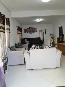 a living room with two white couches and a couch at Beautiful Affordable House - 5 minutes from the airport and 12 minutes to Blue bay beach in Mon Trésor