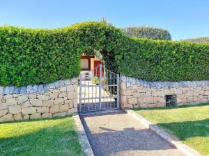 une entrée avec un mur en pierre et un portail dans l'établissement Villa Serene, à Plaia Grande