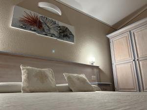 una camera con un letto con due cuscini di Hotel Lu Pitrali a San Teodoro