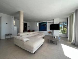 uma sala de estar com um sofá branco e uma mesa em 2b room house with sea view hidromassage and bbq em Talamanca