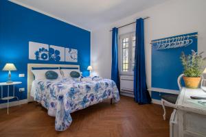ein blaues Schlafzimmer mit einem Bett und blauen Wänden in der Unterkunft Guest House Abbacurrente in Platamona