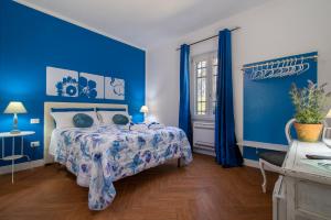 a blue bedroom with a bed and blue walls at Guest House Abbacurrente in Platamona