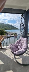 uma cadeira numa varanda com vista para a água em Private Villa by the sea em Žuljana