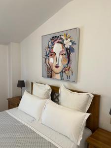a bed with white pillows and a painting on the wall at Casa O Muiño in Poio