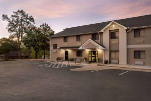a building with a parking lot in front of it at Baymont by Wyndham Hearne in Hearne