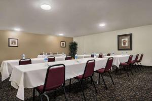 a conference room with long tables and chairs in it at Baymont by Wyndham Hearne in Hearne