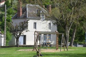un parque infantil frente a una casa blanca en studio "Au Bord de l'Eau" 2, en Chambon-sur-Voueize