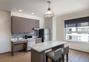 a kitchen with a counter and a refrigerator at Hyatt House Portland/Beaverton in Beaverton