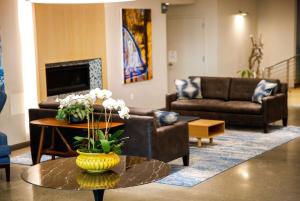 a living room with couches and a table with flowers at Wingate by Wyndham Bronx Haven Park in Bronx