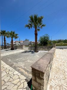 a stone bench in a park with palm trees at Katy's Luxury Apartments in Kavros