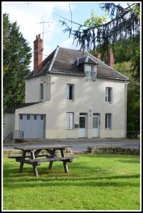 una mesa de picnic frente a una casa blanca en AU BORD DE L'EAU appartement 50 M2, en Chambon-sur-Voueize