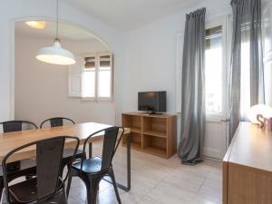 uma sala de jantar com uma mesa e cadeiras e uma televisão em Centric Sagrada Familia Apartments em Barcelona