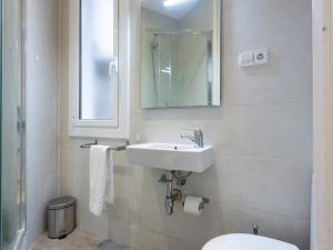 a bathroom with a sink and a toilet and a mirror at Centric Sagrada Familia Apartments in Barcelona