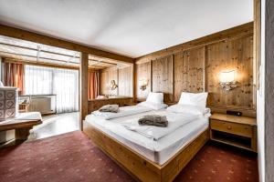 1 Schlafzimmer mit 2 Betten in einem Zimmer mit Holzwänden in der Unterkunft Hotel Alpina Sölden - Adults Only in Sölden