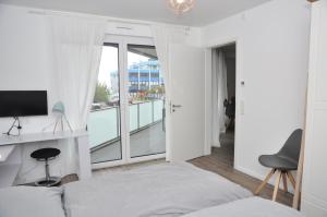 ein Schlafzimmer mit einem Bett und einem Balkon in der Unterkunft Strandmöwe in Laboe