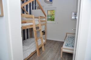 Cette petite chambre dispose de lits superposés et d'une échelle. dans l'établissement Strandmöwe, à Laboe