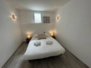een slaapkamer met een bed met 2 kussens erop bij Opale YourHostHelper in Luc-sur-Mer