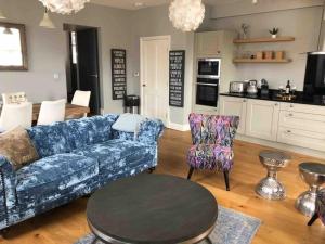 a living room with a blue couch and a table at Luxurious 2 bedroom apartment in central Berwick in Berwick-Upon-Tweed