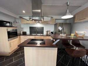 a kitchen with a island with a counter top at Opale YourHostHelper in Luc-sur-Mer