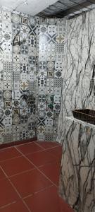 y baño con pared de baldosa y ducha. en H2Homestay phố cổ check in tự động en Hanói