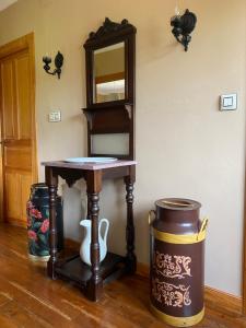 una mesa pequeña con espejo y un cubo de basura en La Pedrosa, en Fontanina