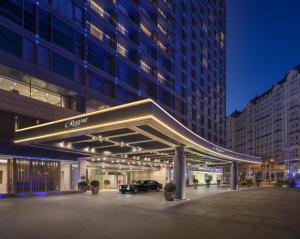 a lit up building with cars parked under it at Regent Beijing in Beijing