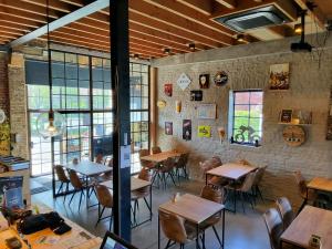 a restaurant with wooden tables and chairs and windows at Kamerrijk in Pepingen