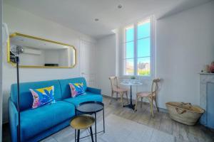 een woonkamer met een blauwe bank en een tafel bij IMMOGROOM-Suquet-AC-WIFI-close to the beaches in Cannes
