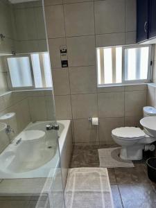 a bathroom with a tub and a toilet and a sink at 204 Marbella Umhlanga in Durban