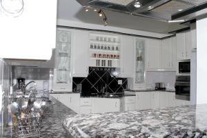 a kitchen with white cabinets and a granite counter top at 204 Marbella Umhlanga in Durban