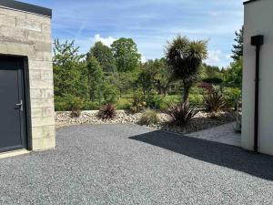 a driveway of a house with a door and a garden at Appartement Le Mans proche du circuit des 24h in Changé
