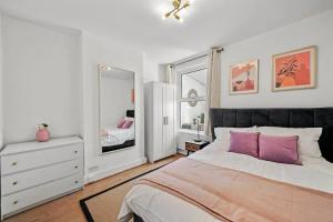 a bedroom with a large bed and a mirror at Bright 2 Bed Perfect Central Hub in London