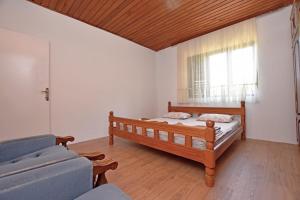 a bedroom with a bed and a couch and a window at Country House Vukmanovic Bukovik in Virpazar