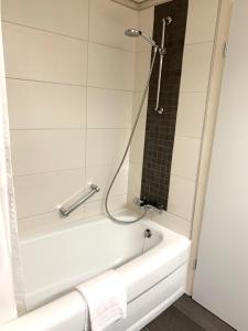 ヴィンターベルクにあるWinterberg Appartement 21041のバスルーム(白いバスタブ、シャワー付)