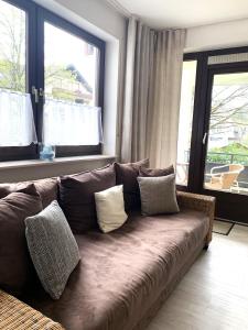 um sofá castanho numa sala de estar com janelas em Winterberg Appartement 21112 em Winterberg