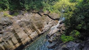 an aerial view of a waterfall on a rocky cliff at Moksha at Kitulgala - Rainforest Boutique Hotel in Kitulgala