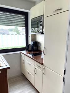 uma cozinha com armários brancos e uma grande janela em Winterberg Appartement 21112 em Winterberg