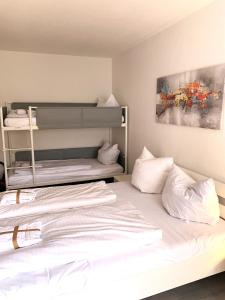 um quarto com 2 beliches e lençóis brancos em Winterberg Appartement 21112 em Winterberg