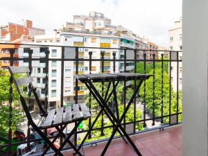 stół i krzesło na balkonie z budynkiem w obiekcie Centric Sagrada Familia Apartments w Barcelonie