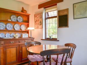 uma sala de jantar com uma mesa de madeira e cadeiras em Wringford Farm Annexe em Cawsand