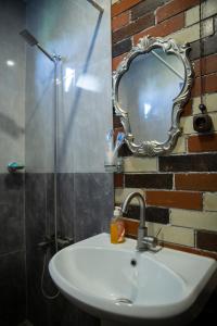 a bathroom with a sink and a mirror on a brick wall at Noravank L-and-L in Namazalu